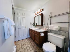 a bathroom with a toilet and a sink and a mirror at Lee's Ocean Peek B & B in Stratford