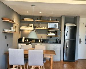 a kitchen with a table and chairs and a refrigerator at Ubicación Exclusiva en Palermo c/ Piscina in Buenos Aires