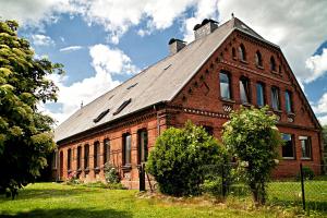 un antiguo edificio de ladrillo rojo con techo gris en Ferien auf Tippen Hof (Bleckede an der Elbe), en Bleckede