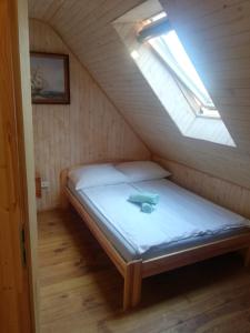 a bed in a small room with a skylight at Bosman Pokoje Gościnne in Mielenko