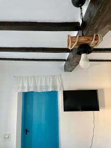 Casa cu stuf Murighiol في موريغيول: مروحة سقف وباب ازرق في الغرفة