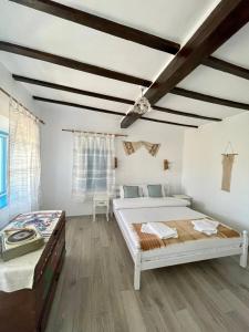 Casa cu stuf Murighiol في موريغيول: غرفة نوم بسريرين وأرضيات خشبية