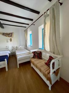 a bedroom with two beds and two windows at Casa cu stuf Murighiol in Murighiol