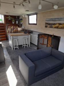 a living room with a blue couch and a kitchen at NEPTUNUS in Nieuwpoort