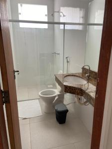 a bathroom with a toilet and a sink and a shower at POMMER POUSADA in Guriri