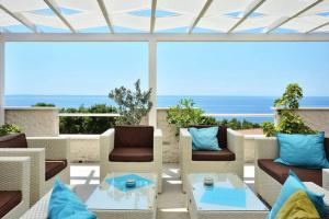 un patio con sillas y mesas y vistas al océano en Apartments Dobrila, en Ivan Dolac