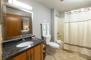 a bathroom with a toilet, sink, and shower at Newport Resort in Egg Harbor