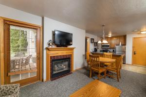 sala de estar con chimenea, mesa y TV en Newport Resort en Egg Harbor