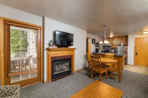 a living room with a fireplace and a table and a television at Newport Resort in Egg Harbor