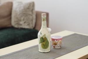 una botella y una taza sobre una mesa en Apartman Star en Subotica