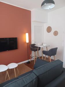 a living room with a couch and a table at Mazamet - Studio neuf et moderne en centre-ville in Mazamet