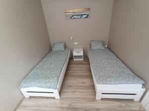 two beds in a small room with at Apartamenty nad Zatoką - Kuźnica in Kuźnica