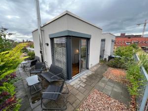 a patio with chairs and a house at Penthouse-Wohnung - Balkon - Dachterrasse - Zentrum in Nürnberg