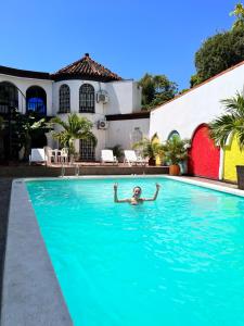 uma pessoa a nadar numa piscina em The Chill in Mansion Hostel Santa Marta em Santa Marta