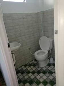 a bathroom with a toilet and a sink at Sky Beach Hotel in Catmon