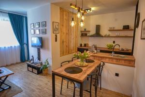 Dream Apartment Vršac في فرساك: مطبخ مع طاولة خشبية وبعض الكراسي