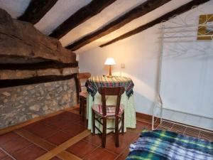a table and chair in a room with a stone wall at R2R - Ático con encanto Colindres - C08B01 in Colindres
