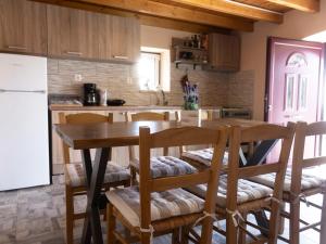 a kitchen with a table and chairs and a refrigerator at Manto's House Lefkada in Évyiros