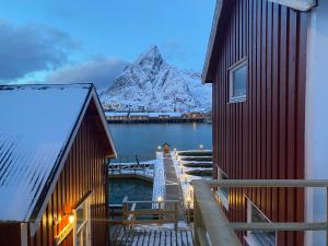 a pier with a boat on the water at Rostad Retro Rorbuer in Reine