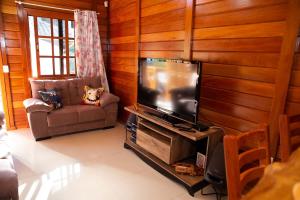 uma sala de estar com uma televisão de ecrã plano e um sofá em Casa de Campo com Churrasq em Marechal Floriano - ES em Marechal Floriano