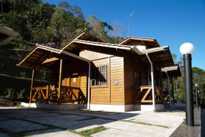 a small wooden building with a porch on a street at Casa de Campo com Churrasq em Marechal Floriano - ES in Marechal Floriano