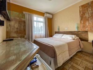 クアトロ・バーハスにあるPousada do Anhangavaのベッドと窓が備わる小さな客室です。