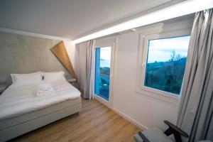 a bedroom with a bed and a large window at Hotel Boutique Berazadi Berri in Zarautz