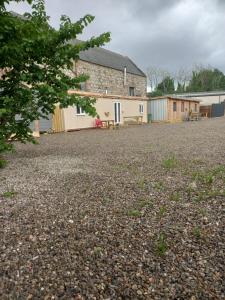 a large gravel driveway with a building in the background at Full Pint in Tain