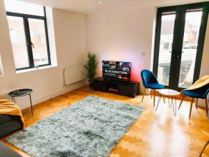 a living room with a couch and a tv at Beautiful Apartment In The Heart of Chelmsford in Chelmsford