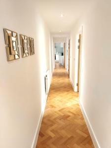 a hallway with white walls and wooden floors at Beautiful Apartment In The Heart of Chelmsford in Chelmsford
