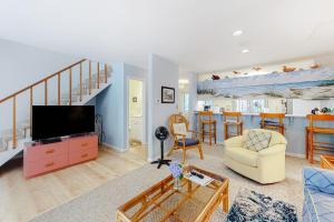 ein Wohnzimmer mit einem Sofa und einem TV sowie eine Küche in der Unterkunft Bayberry Woods -- 714 Bayberry Circle in Bethany Beach