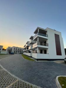 a large white building with a cobblestone street at Apartament Jantar in Jantar