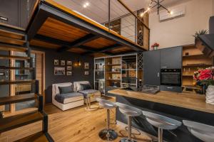 - un salon avec un bar avec des tabourets et un canapé dans l'établissement Studio apartments Atelier, à Rijeka