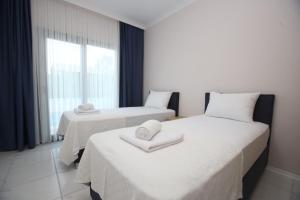 two beds in a hotel room with towels on them at Talia Villalari in Fethiye