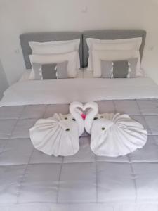 łóżko z dwoma białymi ręcznikami leżącymi na podłodze w obiekcie Casa para ti Villa w mieście Porto Heli