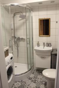 een badkamer met een douche, een toilet en een wastafel bij Galicja Apartamenty in Rzeszów