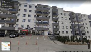 a large building with a parking lot in front of it at Thome Hoia Studio 1Bedroom in Cluj-Napoca