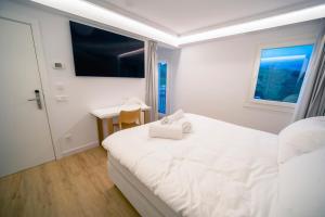 a white bedroom with a bed and a desk at Hotel Boutique Berazadi Berri in Zarautz