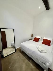 Schlafzimmer mit einem weißen Bett und einem Spiegel in der Unterkunft NEW, La Passante, Belle vue in Conques-sur-Orbiel