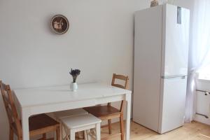 een keuken met een witte tafel en stoelen en een koelkast bij Galicja Apartamenty in Rzeszów