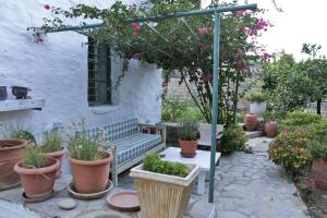a patio with a green bench and some plants at Apatouria Farmhouse in Andros
