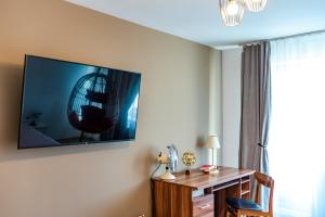 Habitación con escritorio y TV en la pared. en Thome Hoia Studio 1Bedroom en Cluj-Napoca