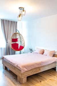 a bedroom with a bed with a hanging basket at Thome Hoia Studio 1Bedroom in Cluj-Napoca