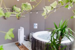 un bagno con vasca rotonda e piante di [ApuliaLux] Design Apartment - Relax, SPA e Free Parking a Bari