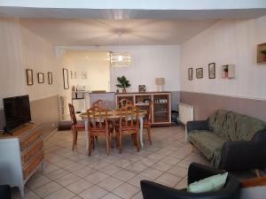 een woonkamer met een tafel en een bank bij Sous murs, petite maison de ville au charme authentique in Auxerre