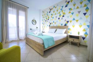 a bedroom with a bed with a geometric wall at Petite palace in Rethymno Town