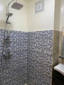 La salle de bains est pourvue d'une douche et d'un lavabo. dans l'établissement Résidence Le joyau de la mer Plage Des Nations, à Sidi Bouqnadel