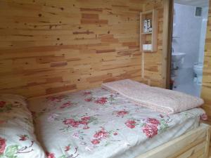 uma cama num quarto com uma parede de madeira em Erdal Pansiyon em Çamlıhemşin
