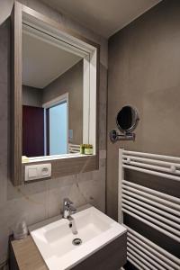 La salle de bains est pourvue d'un lavabo blanc et d'un miroir. dans l'établissement Hotel Uilenspiegel, à Nieuport
