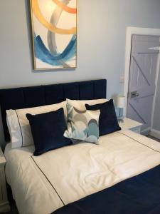 a bed with blue and white pillows on it at 2 Agars Lane Cashel in Cashel